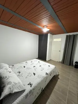 a large bed in a room with a wooden ceiling at Dúplex Céntrico Con Servicios Premium in Medellín