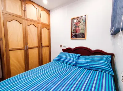a bedroom with a bed with blue striped sheets at Casa de Confort con Parqueadero Privado in Medellín