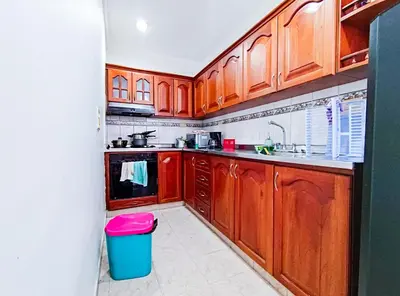 a kitchen with wooden cabinets and a trash can at Casa de Confort con Parqueadero Privado in Medellín