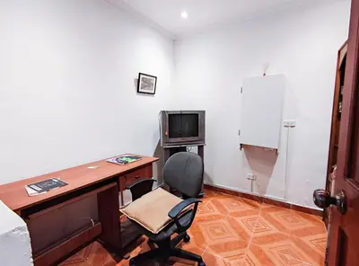 an office with a desk and a chair and a television at Casa de Confort con Parqueadero Privado in Medellín