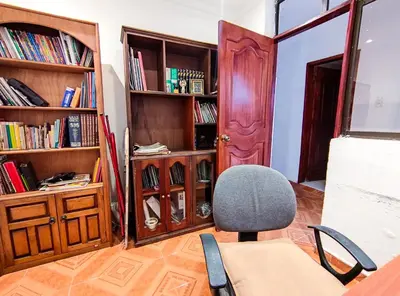 a room with a desk and a chair and book shelves at Casa de Confort con Parqueadero Privado in Medellín