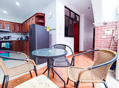 a table and chairs in a kitchen with a refrigerator at Casa de Confort con Parqueadero Privado in Medellín