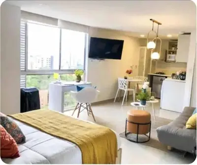a room with a bed and a living room with a kitchen at 1008 New Apartment in Poblado, panoramic view in Medellín