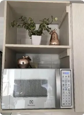 a microwave in a shelf with a potted plant at 1008 New Apartment in Poblado, panoramic view in Medellín