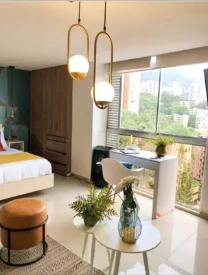 a bedroom with a bed and a desk and a table at 1008 New Apartment in Poblado, panoramic view in Medellín