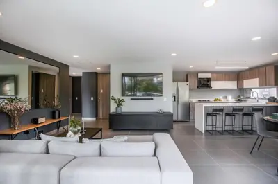 a living room with a couch and a kitchen at Luxury Apartment Poblado in Medellín
