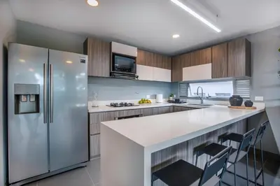 a kitchen with a white counter and a refrigerator at Luxury Apartment Poblado in Medellín