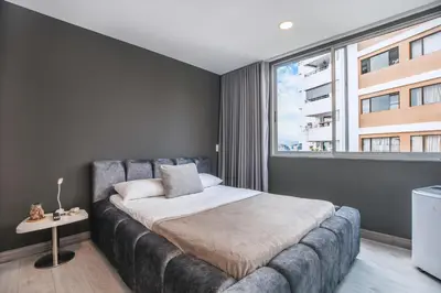 a bedroom with a bed and a large window at Luxury Apartment Poblado in Medellín