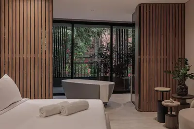 a bedroom with a tub and a bed with towels on it at Premium Smart Loft with Alexa in El Poblado in Medellín