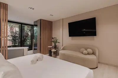 a bedroom with two beds and a television on the wall at Premium Smart Loft with Alexa in El Poblado in Medellín