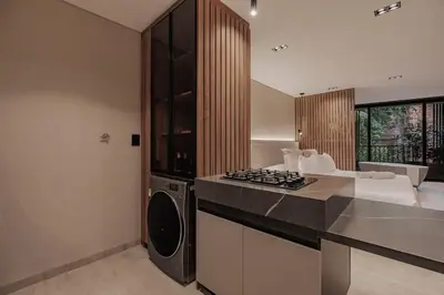 a kitchen with a stove top oven next to a living room at Premium Smart Loft with Alexa in El Poblado in Medellín