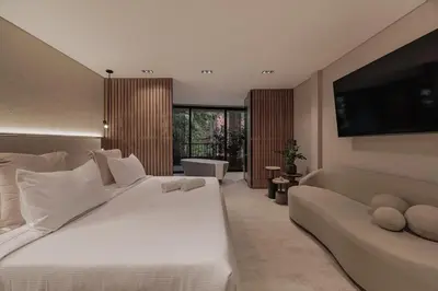 a bedroom with a large white bed and a couch at Premium Smart Loft with Alexa in El Poblado in Medellín