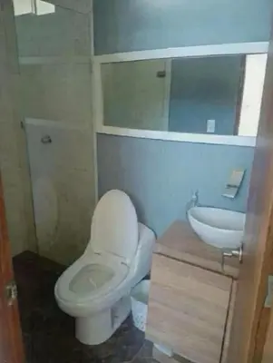 a bathroom with a white toilet and a sink at Serenity Poolside Retreat in Santa Fe Villa Bonita in Santa Fe de Antioquia