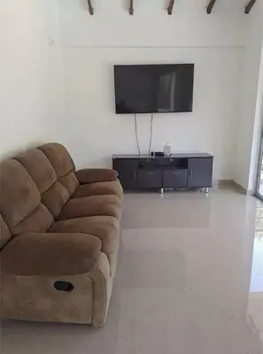 a living room with a couch and a flat screen tv at Serenity Poolside Retreat in Santa Fe Villa Bonita in Santa Fe de Antioquia