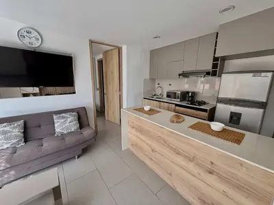 a living room with a couch and a kitchen at Comfy Loft near El Tesoro MDE OSLO in Medellín