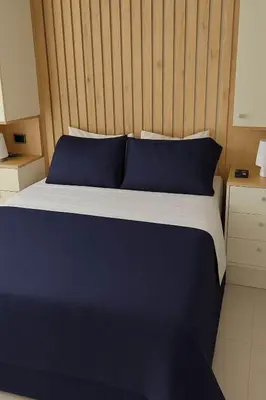 a bed with blue pillows and a wooden headboard at Comfy Loft near El Tesoro MDE OSLO in Medellín