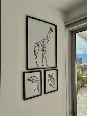 a group of four framed drawings of a giraffe on a wall at Comfy Loft near El Tesoro MDE OSLO in Medellín