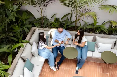 a man and two women sitting on a couch at Casa Fiora Oasis in Medellín
