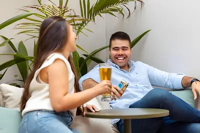 a man and a woman sitting on a couch with a drink at Casa Fiora Oasis in Medellín