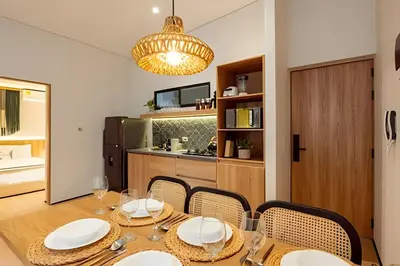 a dining room with a table and chairs and a kitchen at Casa Fiora Oasis in Medellín