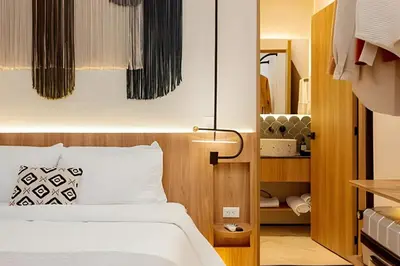 a bedroom with a bed with white sheets and a lamp at Casa Fiora Oasis in Medellín