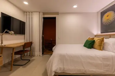 a bedroom with a bed and a desk and a desk at 201 Stylish Retreat in Laureles Area Terrace AC in Medellín