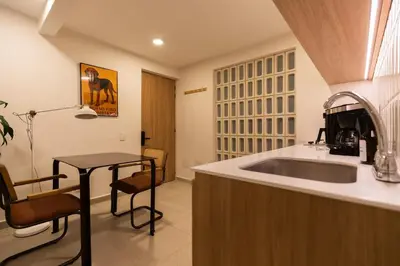 a kitchen with a sink and a counter with a table at 201 Stylish Retreat in Laureles Area Terrace AC in Medellín