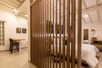 a bedroom with a bed and a table in a room at 301 Live Local Balcony Loft in Vibrant Laureles area in Medellín