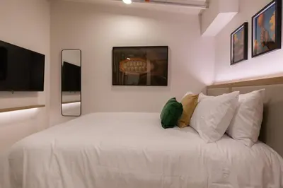 a bedroom with a white bed with pillows and a tv at 303 Balance and Design Loft with AC in Laureles area in Medellín