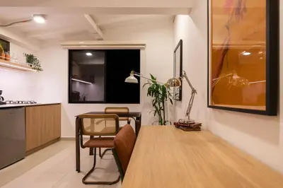 a living room with a table and a kitchen at 303 Balance and Design Loft with AC in Laureles area in Medellín