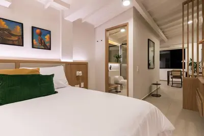 a bedroom with a white bed and a living room at 303 Balance and Design Loft with AC in Laureles area in Medellín