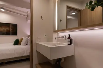 a bathroom with a sink and a mirror and a bed at 303 Balance and Design Loft with AC in Laureles area in Medellín