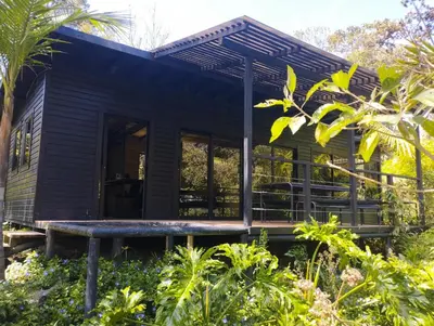 a black tiny house in the jungle at Madremonte Santa Elena finca con cabaña para 2 con piscina natural in Medellín