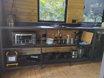 a kitchen with a counter with a microwave and some pots and pans at Madremonte Santa Elena finca con cabaña para 2 con piscina natural in Medellín