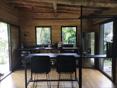 a kitchen with a table and chairs in a room at Madremonte Santa Elena finca con cabaña para 2 con piscina natural in Medellín