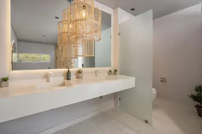 a bathroom with a large mirror and a chandelier at Mansión en las palmas Pool ,Jacuzzi,View in Medellín