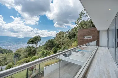 a glass balcony with a view of the mountains at Mansión en las palmas Pool ,Jacuzzi,View in Medellín