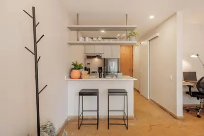 a kitchen with a counter and stools in a room at Loft comodo y central con AC y Terraza propia en Astorga Poblado in Medellín