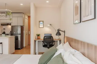 a bedroom with a bed and a desk with a chair at Loft comodo y central con AC y Terraza propia en Astorga Poblado in Medellín