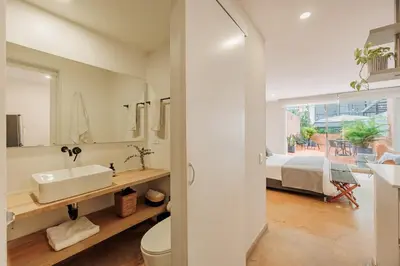 a bathroom with a sink and a toilet and a bedroom at Loft comodo y central con AC y Terraza propia en Astorga Poblado in Medellín