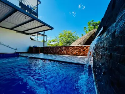 a swimming pool with a water fountain at Villa Paraíso Nápoles in Doradal