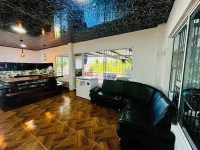 a living room with a leather couch and a table at Villa Paraíso Nápoles in Doradal