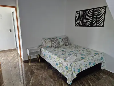 a bedroom with a bed in a white room at Villa Paraíso Nápoles in Doradal