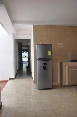 a kitchen with a refrigerator in the middle of a room at Laureles, casa completa y amplia para grupos grandes in Medellín