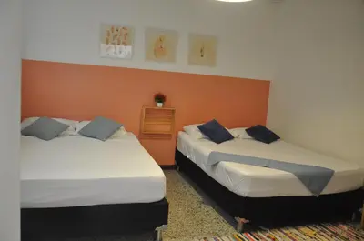 two beds sitting next to each other in a room at Laureles, casa completa y amplia para grupos grandes in Medellín