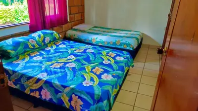 a bed in a room with a blue comforter at Finca - Paraiso in Medellín