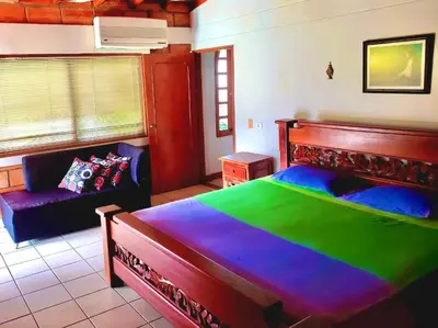 a bedroom with a large bed and a couch at Finca - Paraiso in Medellín