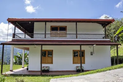 a small white house with a red roof at Entre Cafetales in Jardin