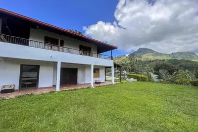 a white house with a green lawn in front of it at Entre Cafetales in Jardin