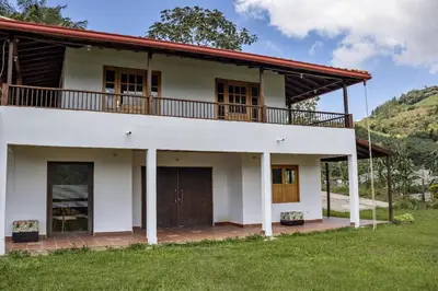 a large white house with a balcony on top at Entre Cafetales in Jardin